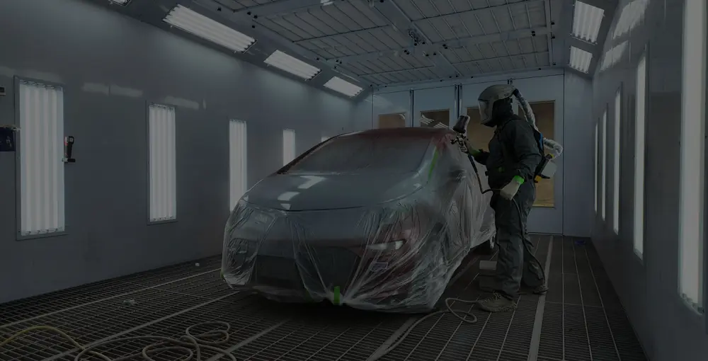 Technician refinishing a vehicle in the Evolution Auto Body paint booth